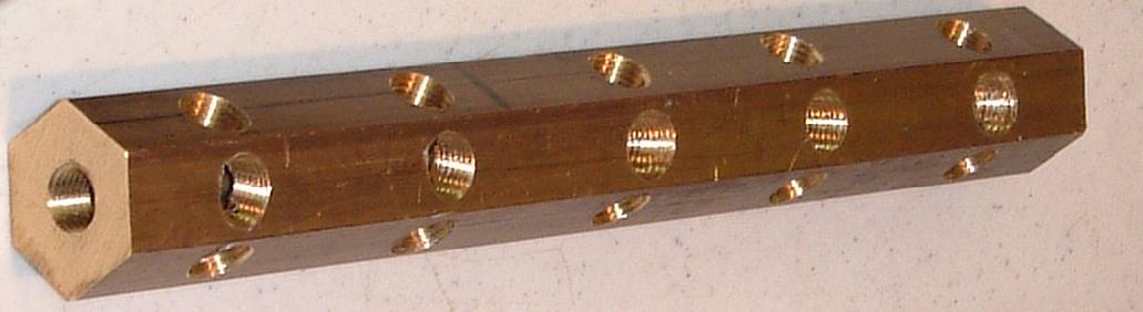 1 Brass hex bar with holes drilled and tapped for 1/4 in NPT